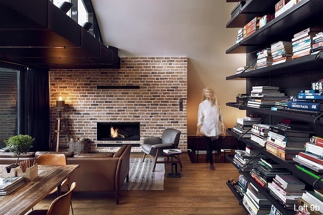 このレンガ壁のリビングルームは、特に暖炉とあふれた本棚と対になっているときは、居心地の良い雰囲気を醸し出すしかできません。部屋全体に使用されている暖かい茶色の色調は、心地良い審美的な効果をもたらすだけです。
