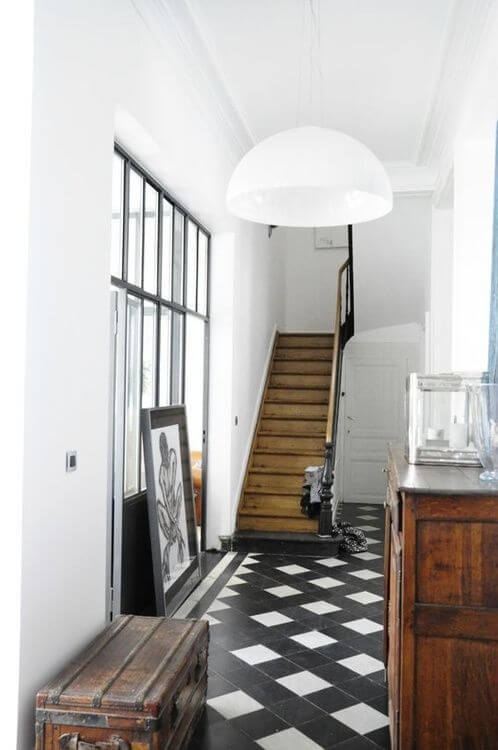 細い通路タイルを敷き詰めて演出しています。どちらかと言うとイギリスによくあるスタイルです。白と黒のタイルを使用しており階段はミディアムブラウンカラーです。家具はアンティーク調でミディアムブラウンカラーで統一しています。