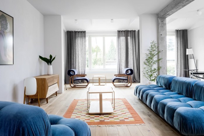 ホワイトに近いフローリングで鮮やかなブルーのソファーを配置してコーディネートしています。木製家具はナチュラルカラーで全体的に優しい印象を与えています。