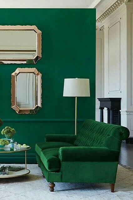 グリーンの壁とソファのややクラシカルな印象のインテリアの画像