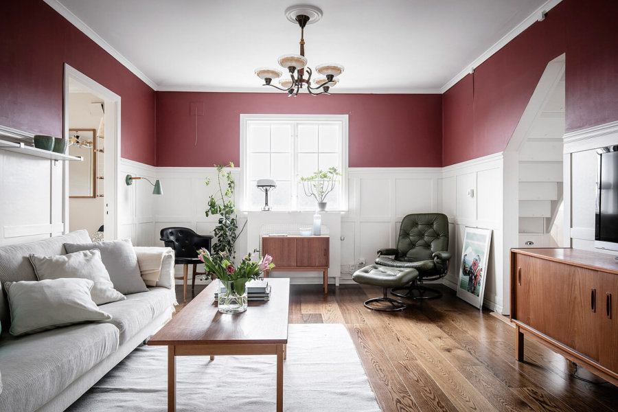 フローリングはミディアムから出ソファーはアイボリーです。木製家具をフローリングの色と揃えています。統一感をそこでしっかり出しておきながら壁面の色で小豆色を使ってアクセントにしています。