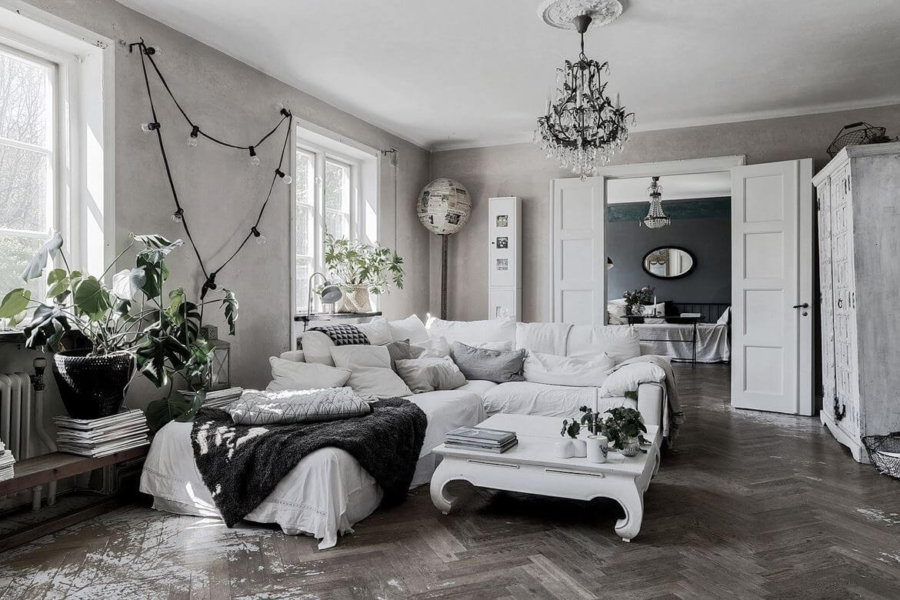 かなり使い込んだグレーのヘリンボーン柄の床と白いソファーのインテリアイメージ。